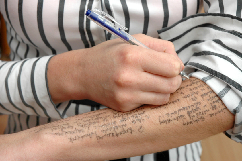 A student writes answers on their arm