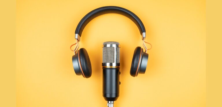 Wireless headphones and a microphone centered in the image on a pale background.