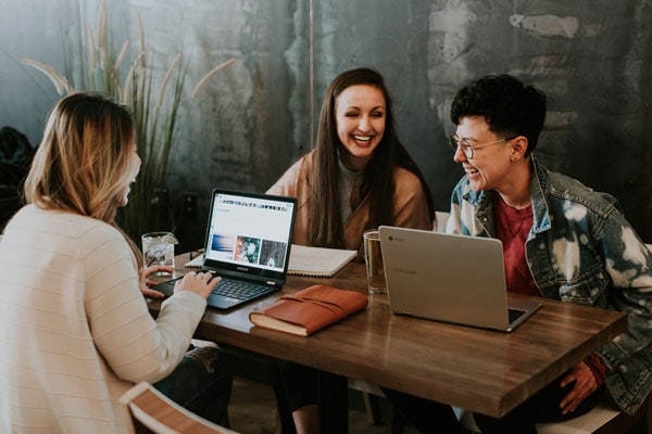 A few women sitting around a table with computers