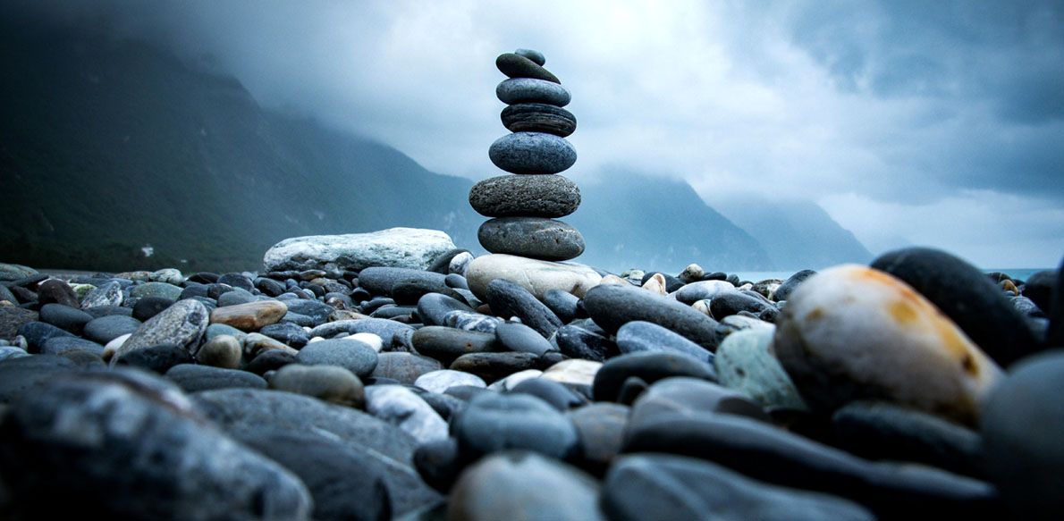Rocks stacked on top of eachother, on a rocky beach.